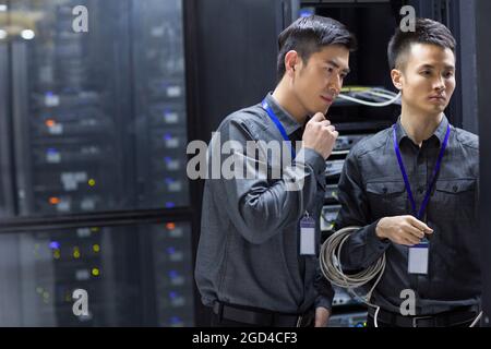 Tecnici che eseguono la manutenzione nella sala computer Foto Stock