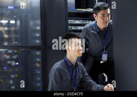 Tecnici che eseguono la manutenzione nella sala computer Foto Stock