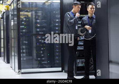 Tecnici che eseguono la manutenzione nella sala computer Foto Stock