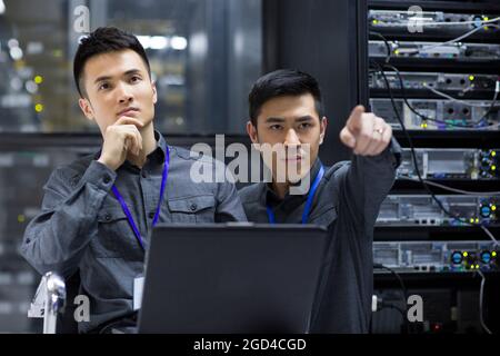 Tecnici che eseguono la manutenzione nella sala computer Foto Stock