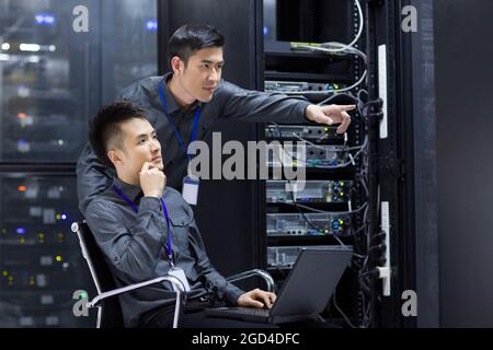 Tecnici che eseguono la manutenzione nella sala computer Foto Stock