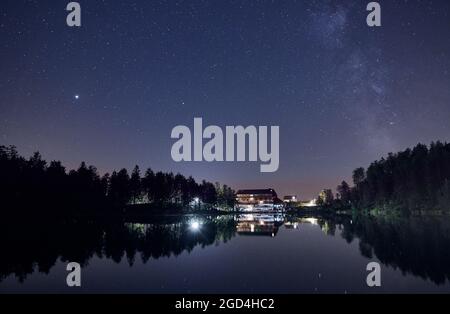 Cielo notturno con campo stellare e la strada lattea sul lago Mummelsee a Seebach, Foresta Nera, Germania, Europa. Foto Stock