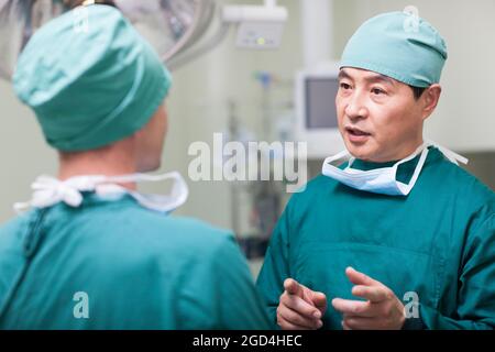 I chirurghi parlando in sala operatoria Foto Stock