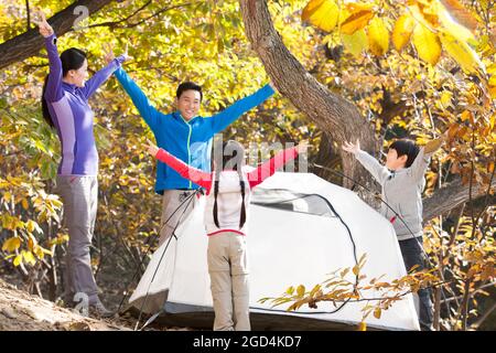 La famiglia eccitata a creare una tenda in campeggio Foto Stock