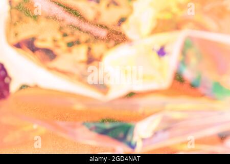 Sfondo olografico sfocato. Sfocata struttura multicolore di lamina rugosa in colori arancio. Foto Stock