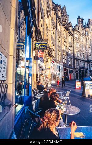 I clienti mangiano e bevono al ristorante Petite Paris e al Pavement Cafe a West Bow, Edimburgo, Scozia, Regno Unito Foto Stock