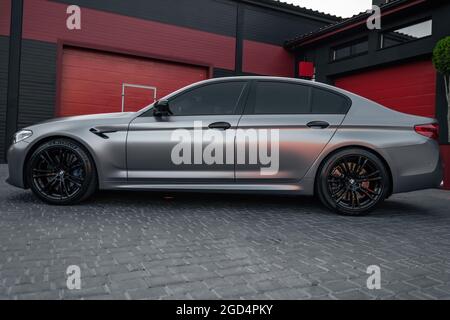 Ucraina, Odessa - 8 luglio 2021: BMW M5 Platinum. Un'auto sportiva di lusso dal colore grigio opaco e dal colore nero rimmed sul parcheggio vuoto Foto Stock