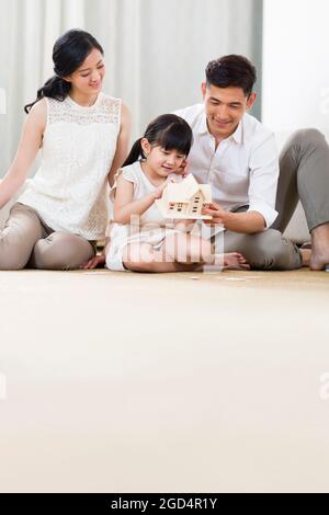 Giovane famiglia che gioca edificio in soggiorno Foto Stock