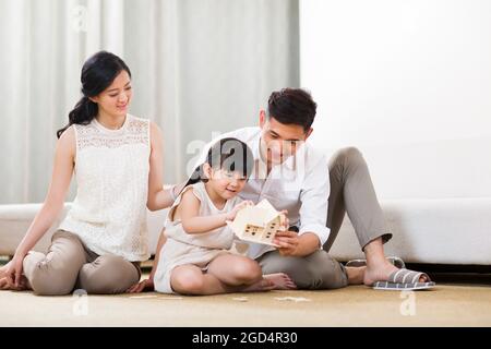 Giovane famiglia che gioca edificio in soggiorno Foto Stock