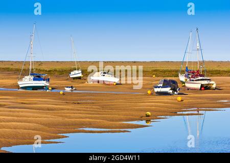 Varie barche da pesca che si stagliano in un'aground a bassa marea a Wells-next-the-Sea, Inghilterra. Foto Stock