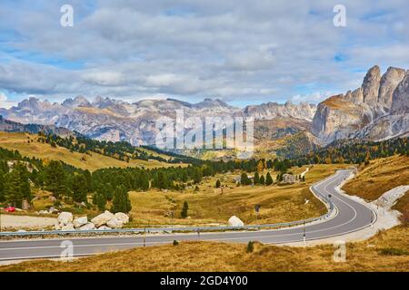 Vista della strada tortuosa. Strade asfaltate nelle alpi italiane in Alto Adige, durante la stagione autunnale. Autunno in scena con la strada curva e larici giallo da bo Foto Stock