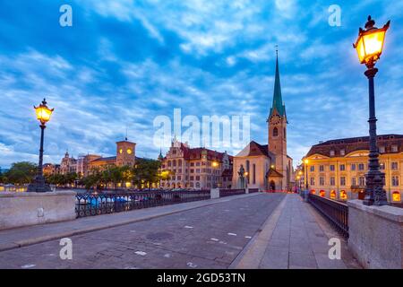 Ponte Munsterbrucke e il campanile della chiesa Fraumunster al tramonto. Foto Stock