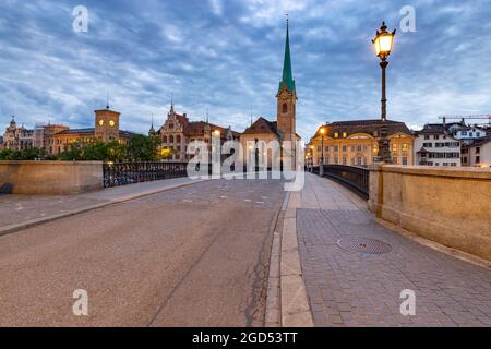 Ponte Munsterbrucke e il campanile della chiesa Fraumunster al tramonto. Foto Stock