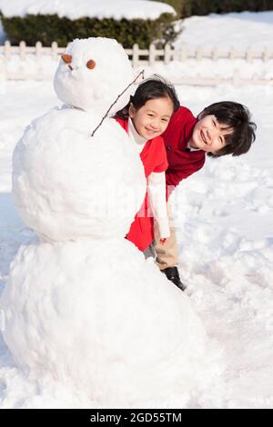 Bambini allegri con pupazzo di neve Foto Stock