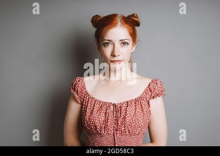 ritratto interno di giovane donna sorridente con ciambelle rosse spazio capelli Foto Stock