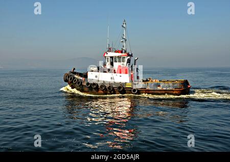 Mare con vista panoramica di un tugboat locale sulle acque della Baia di Guanabara a Rio de Janeiro, Brasile. Foto Stock