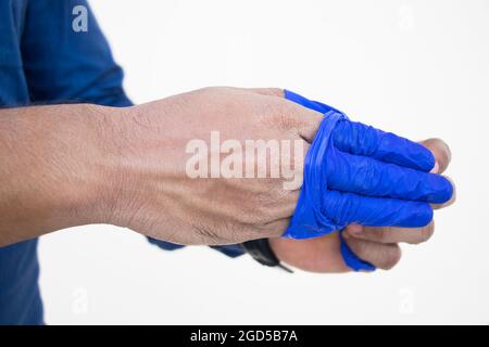 Primo piano Doctor che rimuove i guanti dalla mano Foto Stock