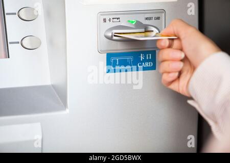 Primo piano di uomo d'affari che inserisce la carta bancaria nel bancomat Foto Stock