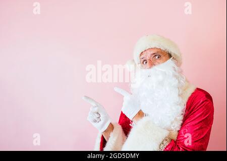 Uomo vestito da Babbo Natale che indica da parte Foto Stock