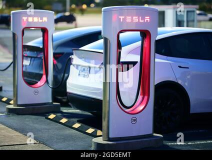 Due caricabatteria Tesla di notte. Foto Stock