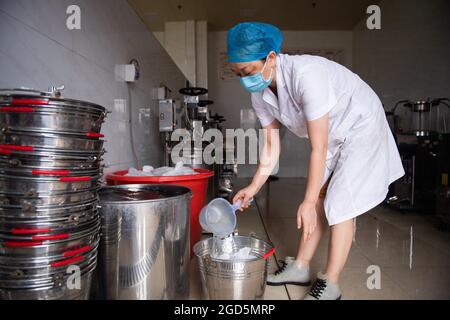 Zhangjiajie, provincia di Hunan in Cina. 11 Agosto 2021. Un farmacista immerge la medicina cinese tradizionale (TCM) in un ospedale di TCM a Zhangjiajie, provincia di Hunan della Cina centrale, 11 agosto 2021. Oltre 12,000 dosi di decotti TCM vengono effettuate dall'ospedale ogni giorno per aiutare a controllare il recente picco di infezioni COVID-19 in Zhangjiajie. Credit: Chen Sihan/Xinhua/Alamy Live News Foto Stock