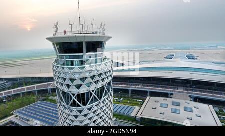 Qingdao, la provincia cinese di Shandong. 11 Agosto 2021. La foto aerea mostra la torre di controllo del traffico aereo dell'Aeroporto Internazionale di Qingdao Jiaodong a Qingdao, nella Provincia di Shandong della Cina orientale, 11 agosto 2021. Il nuovo aeroporto internazionale di Qingdao Jiaodong sarà operativo il 12 agosto, mentre il vecchio aeroporto internazionale di Qingdao Liuting sarà chiuso. Posizionato come aeroporto hub internazionale nel nord-est asiatico, il nuovo aeroporto è destinato a soddisfare 35 milioni di passeggeri annui entro il 2025. Credit: Li Ziheng/Xinhua/Alamy Live News Foto Stock