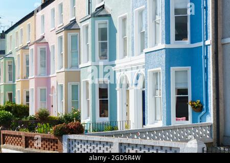 Case residenziali a schiera in stile edoardiano dipinte di colore con finestre a bovindo sulla West End Street a Beaumaris Anglesey Foto Stock