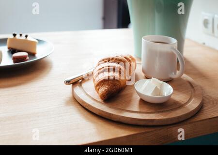 un croissant di caffè e burro si siede sul davanzale. Foto Stock