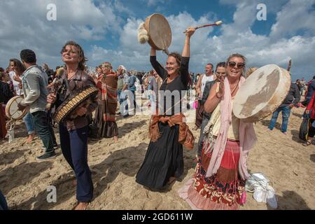 Spiaggia di Scheveningen, l'Aia, Paesi Bassi. Domenica 8 agosto, 2021. Centinaia di manifestanti di ‘New-age’ si sono riuniti per cantare, ballare e battere il tamburo Foto Stock