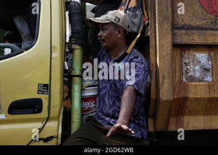 Bandung, Giava Occidentale, Indonesia. Un uomo spazzatura è in un camion della spazzatura che va intorno ogni casa raccogliendo i rifiuti. Foto Stock