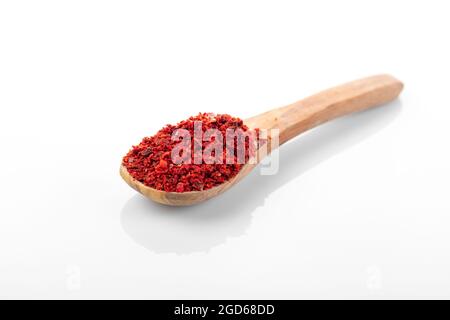 Peperoncino in scaglie. Peperoncino in fiocchi di peperoncino bianco su sfondo bianco. Macroscopio al peperoncino. Foto Stock