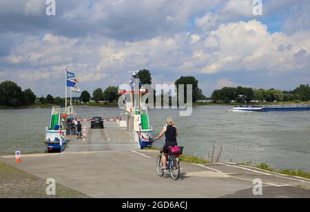 Düsseldorf (Kaiserswerth), Germania - 9 luglio. 2021: Vista sul fiume reno con traghetto per passeggeri, auto e biciclette Foto Stock