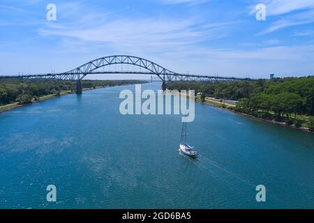 Barca a vela che passa sotto il ponte di Bourne, canale di Capo Cod Foto Stock