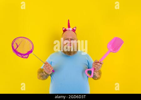 uomo grasso con fascia gioco con rete di mare e pagaia Foto Stock