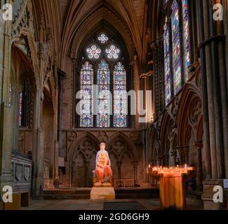 Statua di Maria e Gesù accanto a un supporto di candele accese nella cappella della Signora della cattedrale cristiana medievale a Lincoln, Inghilterra. Foto Stock