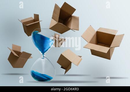 scatole di cartone e clessidra. Concetto di consegna rapida in breve tempo. Deposito temporaneo, offerta limitata e sconto. Ottimizzazione della consegna Foto Stock