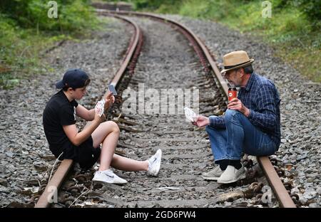 Uomo e ragazzo giocando carte sulla ferrovia Gran Bretagna, Regno Unito gioco d'azzardo Foto Stock