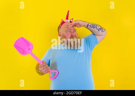 fat uomo con archetto gioco con paddle mare Foto Stock