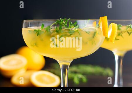 Cocktail Meyer Lemon e Thyme Bees: Cocktail in gin preparati con succo di limone Meyer e guarniti con sprigs al timo e un tocco di originalità Foto Stock