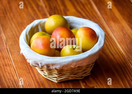 Mirabelle prugne in un cestino su un tavolo di legno Foto Stock