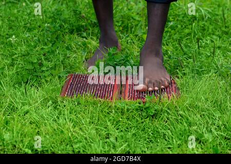 piedi di un uomo in piedi su una tavola di yoga sadhu con unghie all'aperto Foto Stock