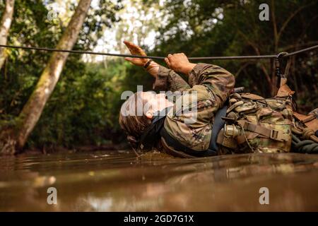 Brianne Hanley dal 3° Team di combattimento della Brigata della Fanteria, la 25° Divisione della Fanteria attraversa un fiume con un ponte di corda durante l'allenamento in acqua il 6° giorno del corso di addestramento sulla giungla (JOTC) a East Range, Hawaii, il 27 marzo 2021. Dirigenti e soldati senior della 25a Divisione Fanteria partecipano a JOTC per familiarizzare e certificarsi con le tattiche, le tecniche e le procedure operative della giungla necessarie per combattere, vincere e sopravvivere in qualsiasi ambiente tropicale della giungla. (STATI UNITI Foto dell'esercito del 1° Lt. Angelo Mejia) Foto Stock