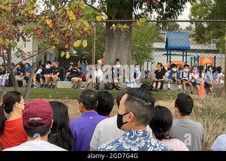 La gente guarda mentre gli studenti arrivano per il primo giorno di scuola alla scuola elementare di Brightwood, mercoledì 11 agosto 2021, a Monterey Park, Calif. Foto Stock