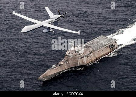 OCEANO PACIFICO (21 aprile 2021) un sistema di aerei di sorveglianza marittima senza equipaggio mq-9 Sea Guardian sorvola la nave da combattimento a terra USS Coronado (LCS 4), variante Independence, durante il Unmanned Systems Integrated Battle Problem (UxS IBP) 21 della flotta statunitense del Pacifico, aprile 21. UxS IBP 21 integra funzionalità con e senza equipaggio in scenari operativi difficili per generare vantaggi in termini di lotta. (STATI UNITI Foto della Marina di Shannon Renfroe, Capo di comunicazione di massa) Foto Stock