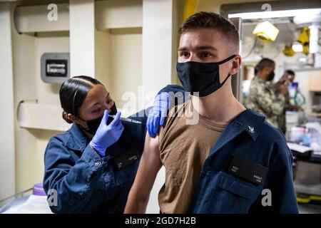 210423-N-PC065-1019 NORFOLK, Va. (23 aprile 2021) Hospitalman JLyn Bautista, assegnato alla nave da carico anfibia di classe San Antonio USS Arlington (LPD 24) somministra un vaccino COVID-19 al Retail Specialist 3a Classe Nicholas Wingle, 23 aprile 2021. Arlington è una casa a Norfolk, Virginia. (STATI UNITI Navy Photo by Mass Communication Specialist 2° Classe John D. Bellino/Released) Foto Stock