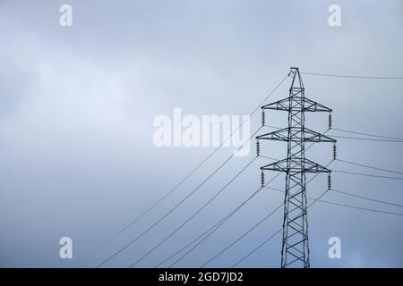 Traliccio elettrico su cielo blu nuvoloso Foto Stock