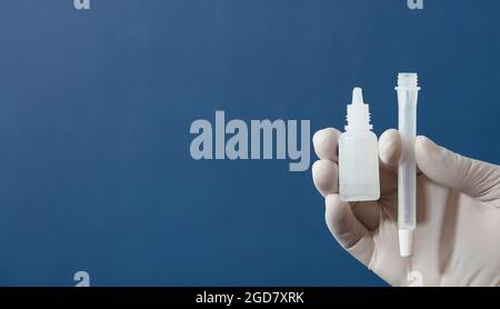 l'infermiere o il medico esegue il test dell'antigene, con sfondo blu Foto Stock