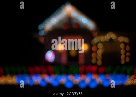 Foto sfocata di una casa di pan di zenzero-sguardo decorata con luci di Natale di vari colori - stagione di festa cheer concetto Foto Stock