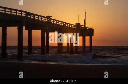 Alba al molo di St. Augustine Beach (St John's County Ocean Pier) con pescatori dalle silhouette. Foto Stock