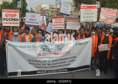 Lahore, Pakistan. 11 Agosto 2021. Gli attivisti pakistani di Rawadari Tehreek tengono cartelli mentre marciano per celebrare la Giornata Nazionale delle minoranze a Lahore. Il presidente Samson Salamat guida il rally. (Foto di Rana Sajid Hussain/Pacific Press) Credit: Pacific Press Media Production Corp./Alamy Live News Foto Stock